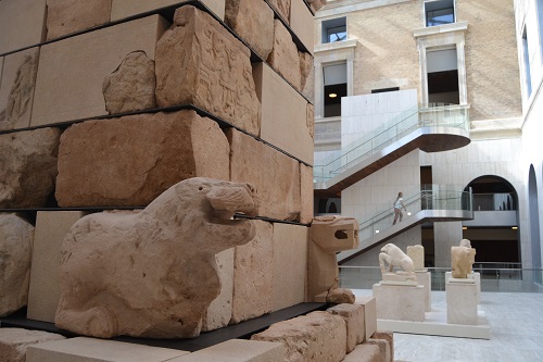 The tower has felines at each corner and the sides are decorated with bas-reliefs showing cryptic scenes such as a horned figure with a knife raised over a man who sits in a cauldron. Another scene shows a two-headed boar rooting in the ground and uncovering a snake, which coils around the animal's legs while turning into a human.