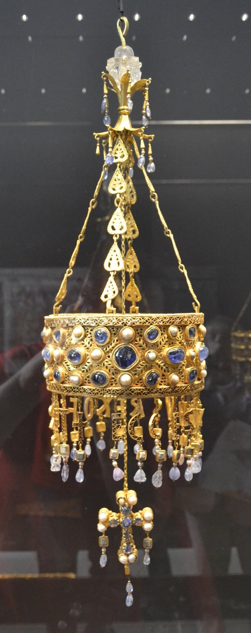 Reccesvinth's crown from the Guarrazar Hoard. A collection of gold crowns and crosses dating between 621 and 672 AD, these masterpieces of Visigothic art show Late Roman and Byzantine influences. This crown, for example, has a reused Byzantine pectoral cross. It was popular for royalty, clergy, and leading civilians to donate crowns and crosses as votive offerings.