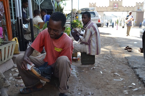 These shoe shiners in Harar, Ethiopia, use munitions boxes to store their tools and also as seats.
