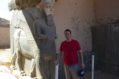 Still surviving, but for how long? The author next to a winged bull at Nimrud.