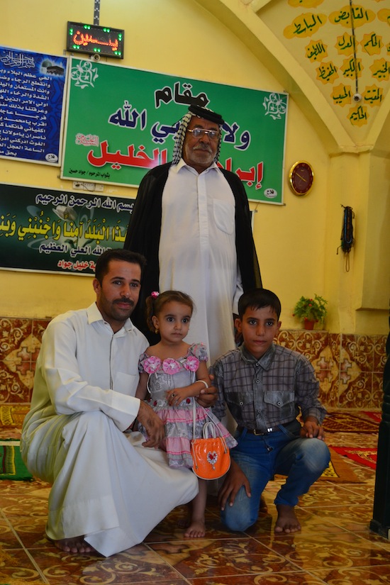 Three generations at a Shia shrine.